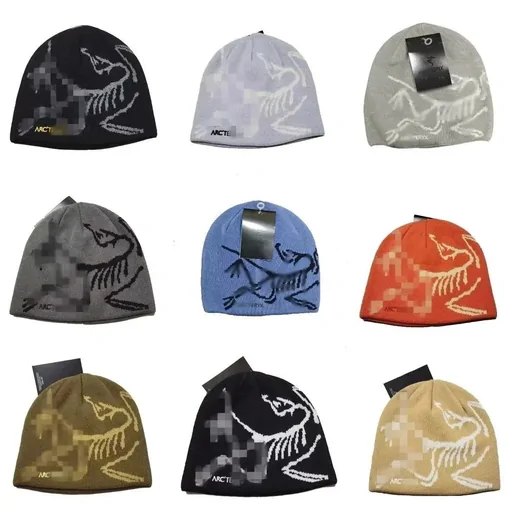 Nine fine-knit beanies in different colours, each with a large white line-drawing embroidery
