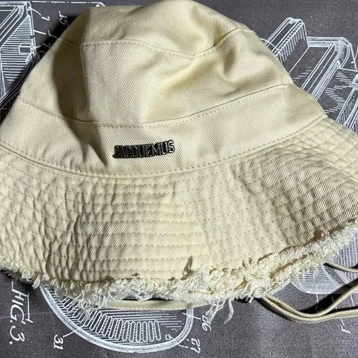 Cream canvas bucket hat with a frayed, unhemmed brim