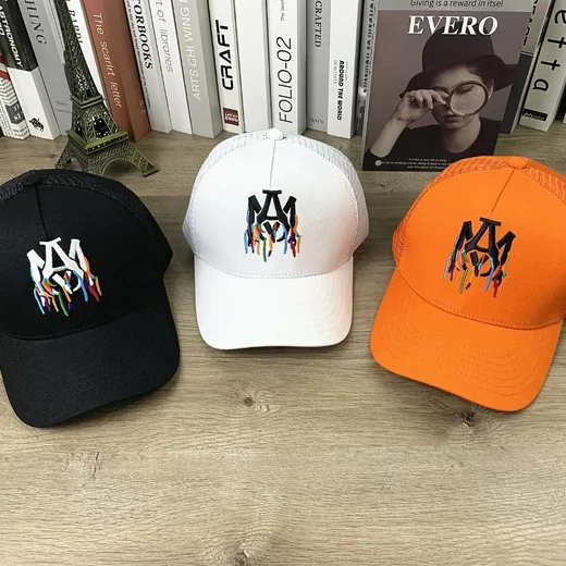 Black, white and orange trucker caps with colourful dripping embroidery on the front