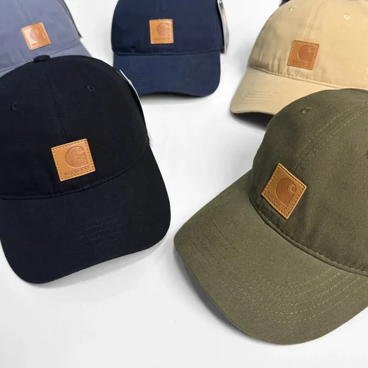 Three canvas baseball caps in navy, olive green and beige with small square patches