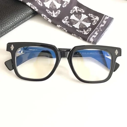 Black acetate square glasses with clear lenses resting on a printed pouch