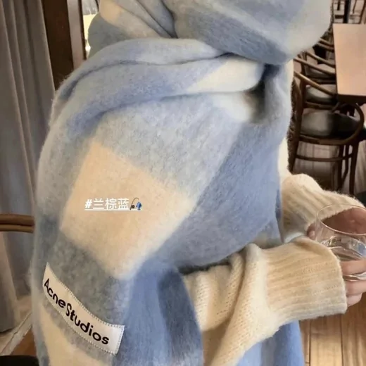 Woman wrapped in a large pale blue and white check scarf