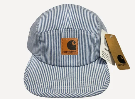 Pale blue pinstriped work cap with a brown patch and a paper tag