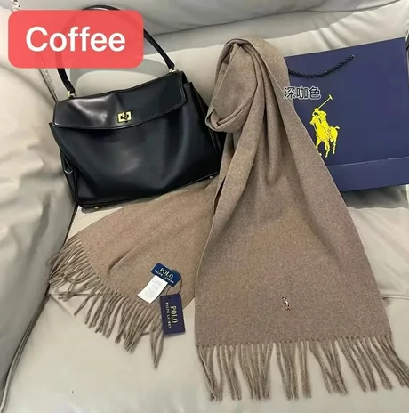 Coffee-coloured fringed scarf draped beside a black handbag and a paper bag