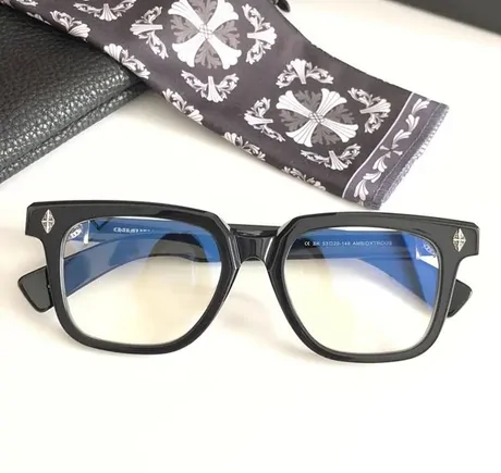 Black square glasses frame with tinted lenses on a white background beside a printed pouch