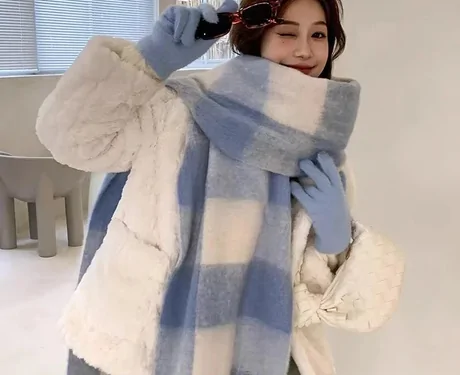 Woman wrapped in a thick pale blue and white check scarf