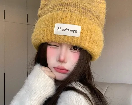 Woman wearing a fluffy mustard beanie with two knitted ear points
