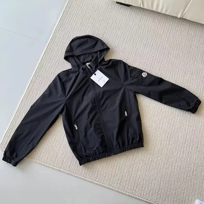 Navy hooded zip jacket hanging against a plain wall